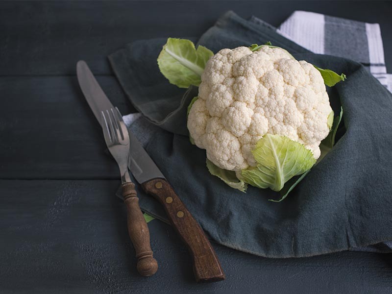 Frischer Blumenkohl auf Holzuntergrund – vielseitiges Low-Carb-Gemüse und beliebte Zutat in der ketogenen Ernährung, kalorienarm und nährstoffreich.